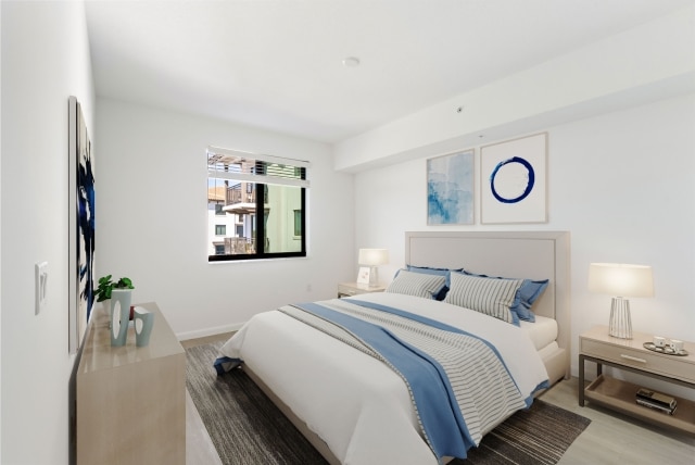 Spacious apartment bedroom with white oak plank flooring inside homes at Casa Mara